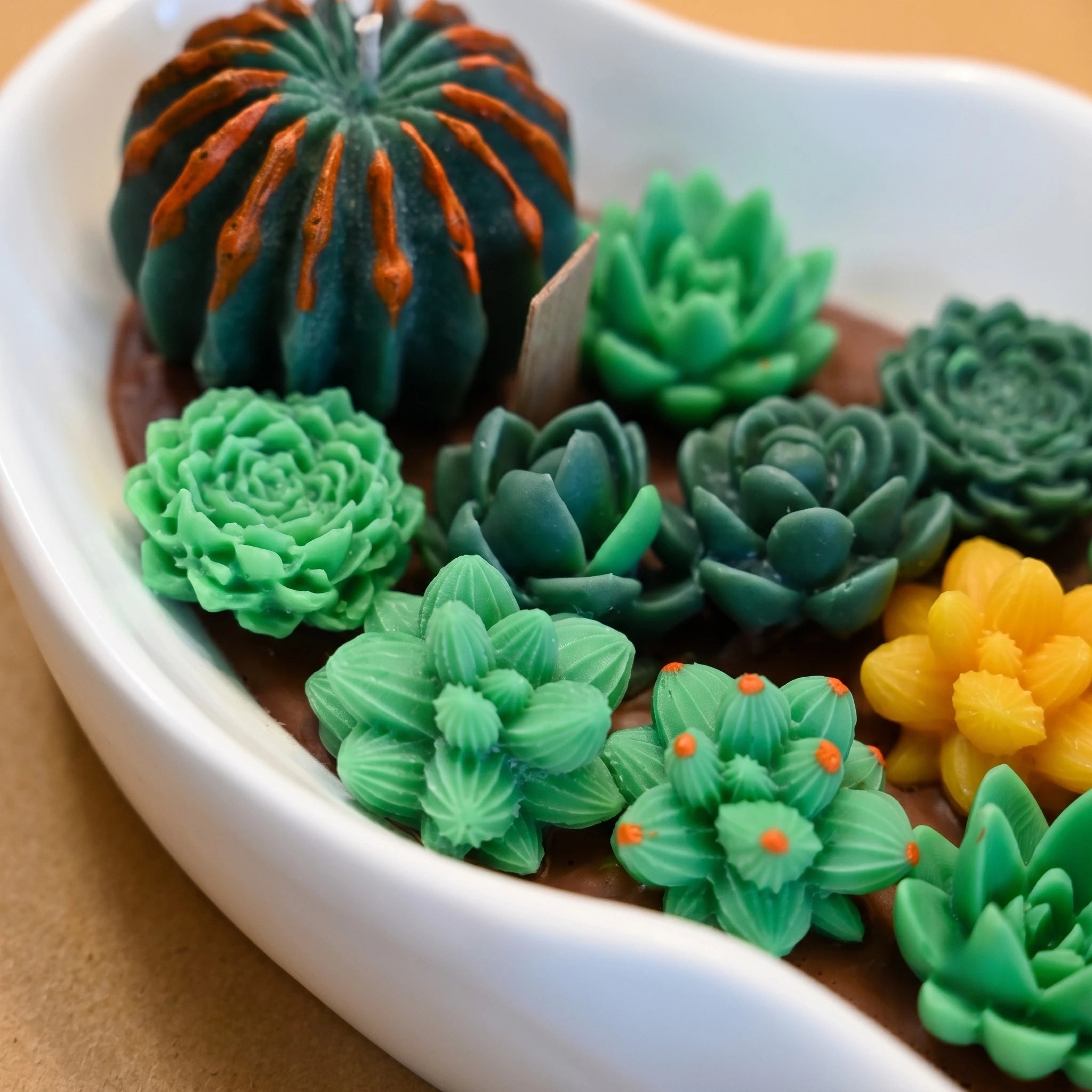 Close-up of hand-sculpted soy wax succulents in sage and forest green on the House of Wick Desert Oasis candle