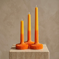 Gradient fluted vase candles in warm ombre tones displayed on a stone surface by House of Wick