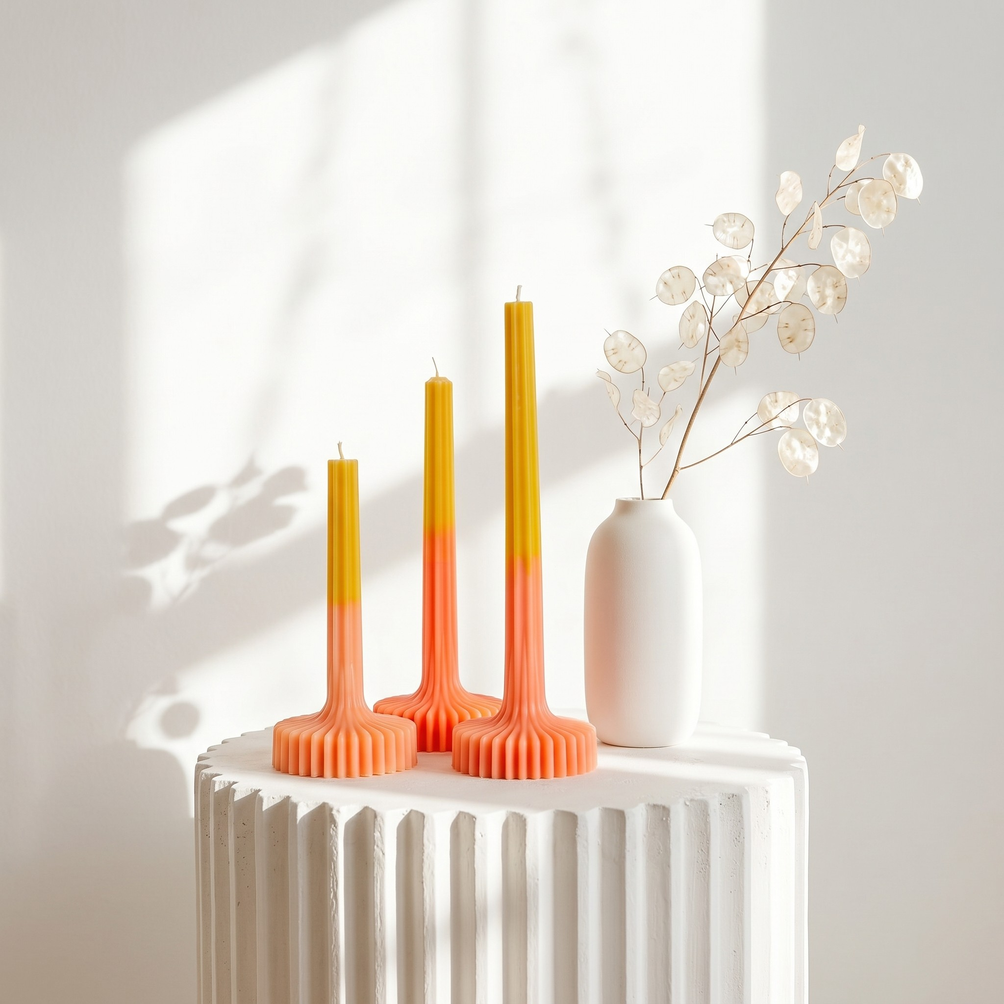 Modern fluted taper candles displayed on a minimalist white pedestal by House of Wick
