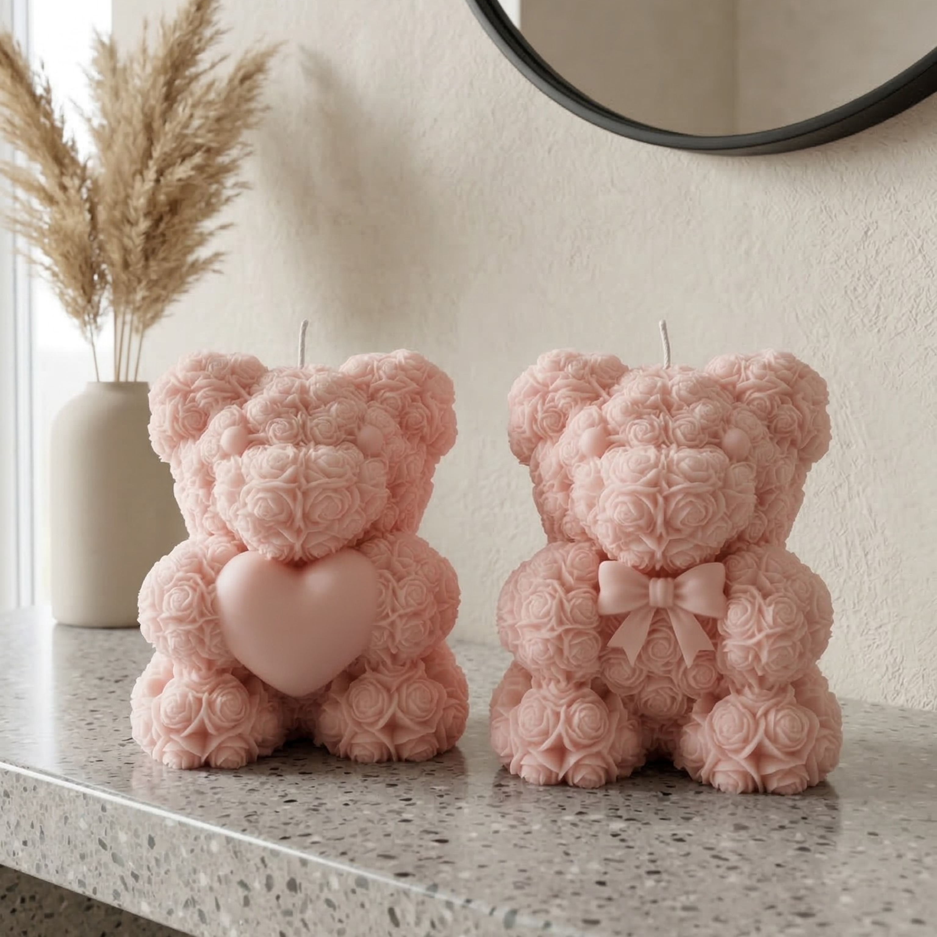 Set of light pink teddy bear candles with heart and bow displayed on a modern console table
