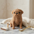 Tan pug candle on marble with matches and gold candle snuffer