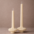 Modern sculptural vase pillar candles made from natural soy wax with a fluted base design displayed against a warm neutral background.