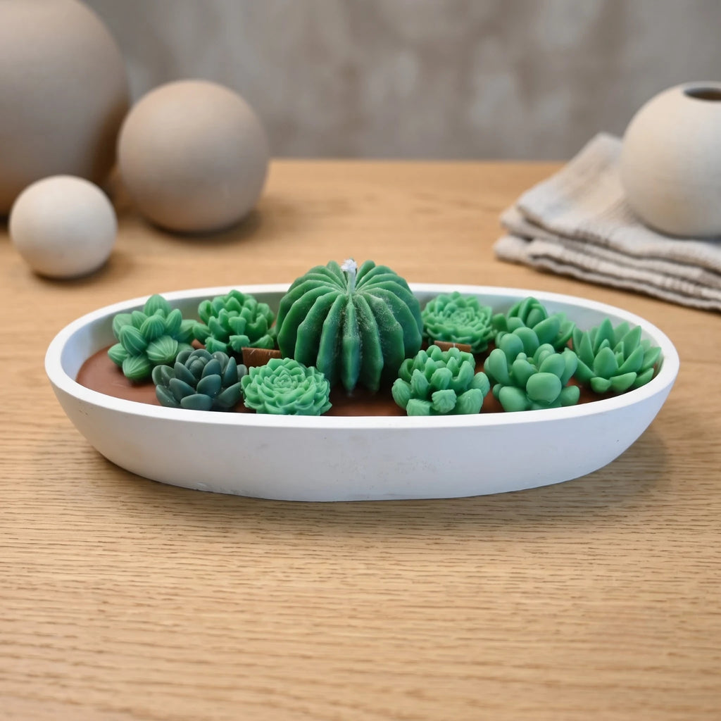 Succulent Garden candle by House of Wick hand-sculpted green succulents in a white oval eco resin bowl on a wood table