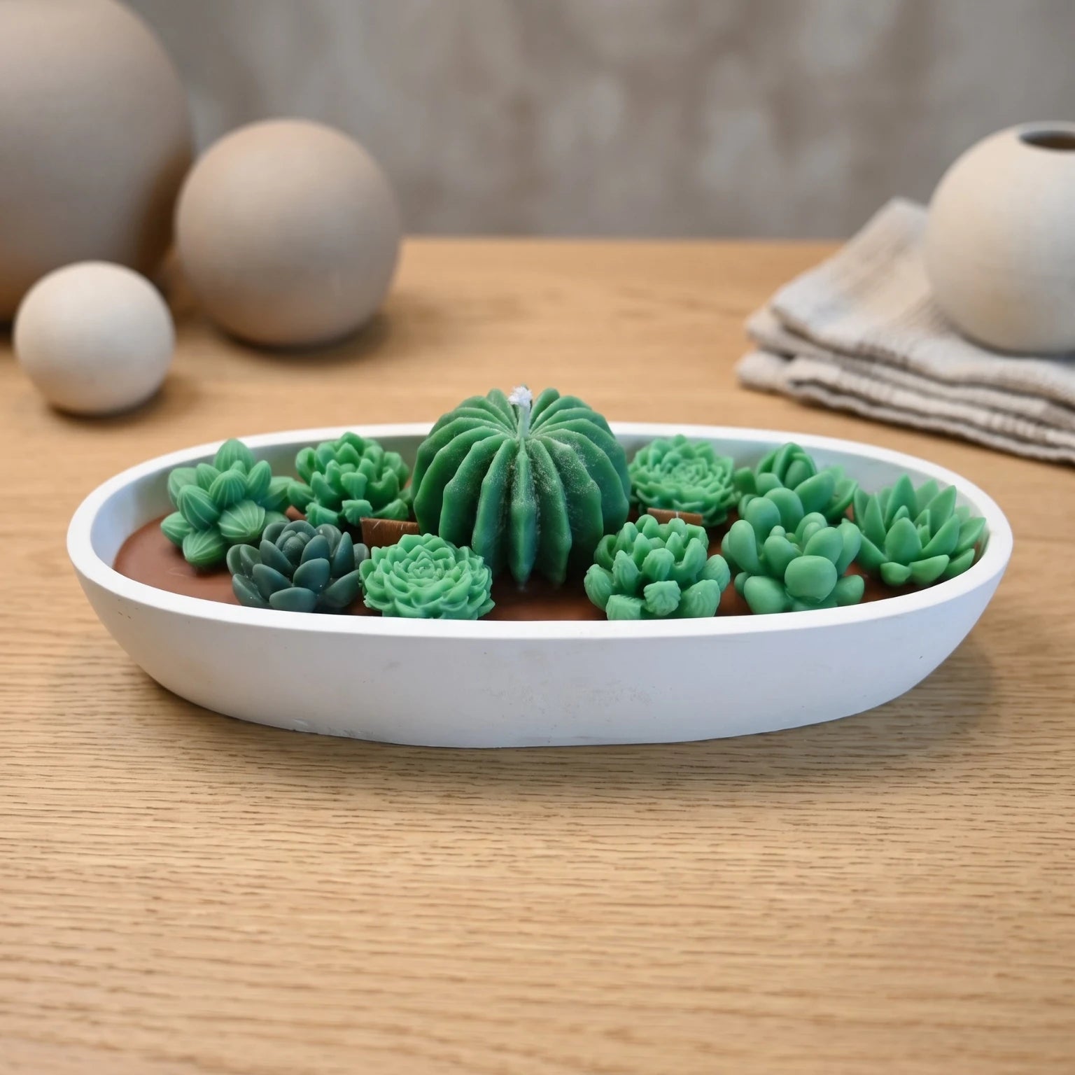 Succulent Garden candle by House of Wick hand-sculpted green succulents in a white oval eco resin bowl on a wood table