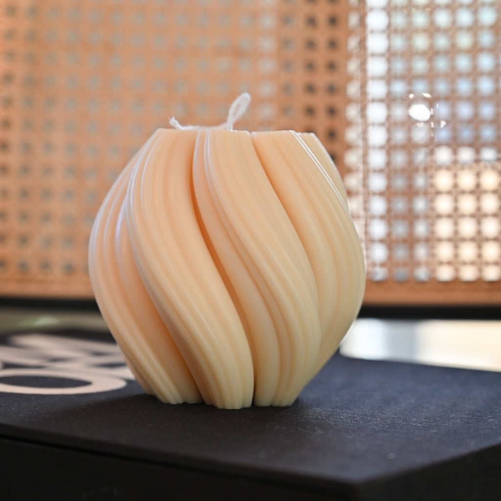 Hand-poured swirl candle by House of Wick displayed on branded box highlighting sculptural curves and neutral minimalist decor styling.
