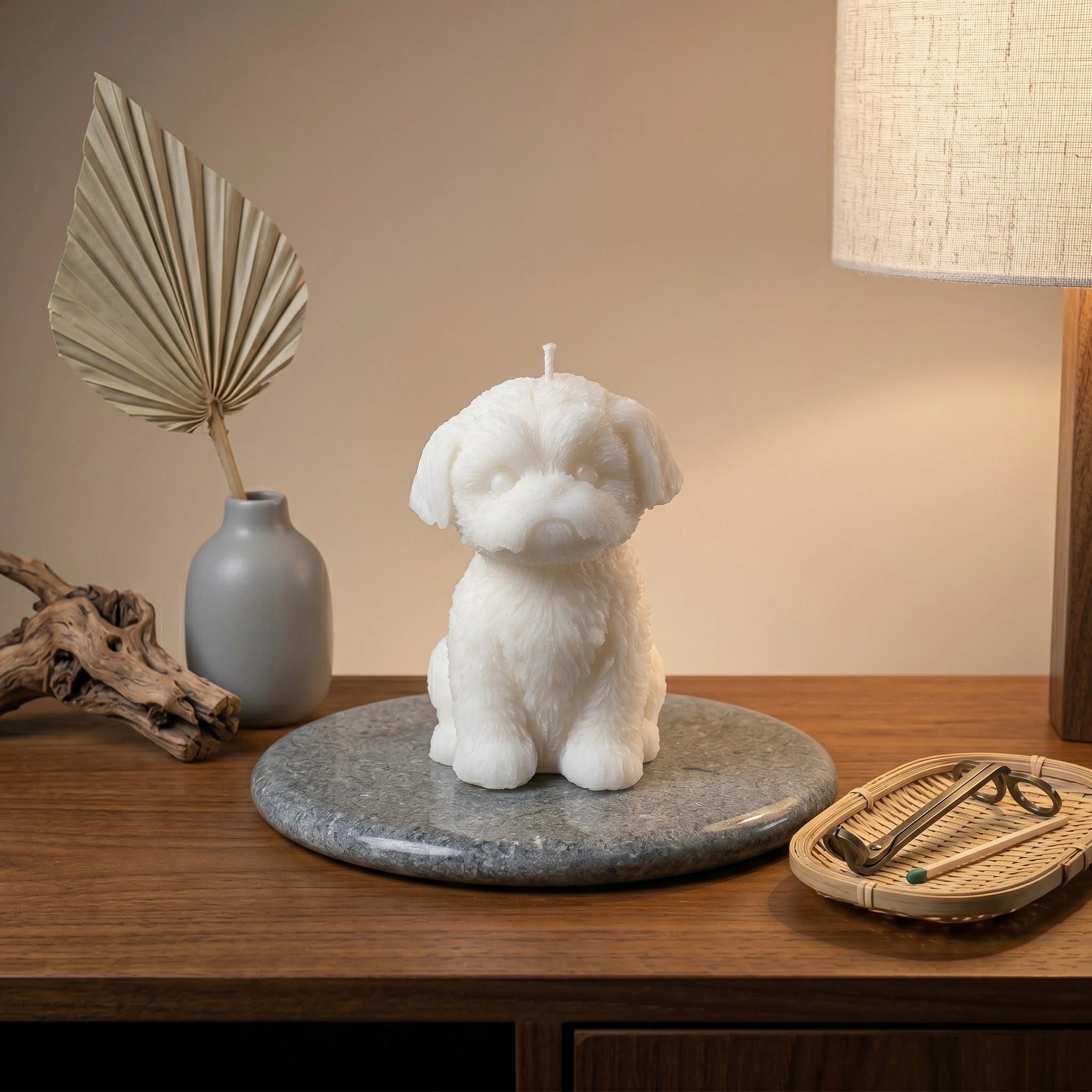 White Shih Tzu puppy candle lifestyle on wood table with eucalyptus and tray