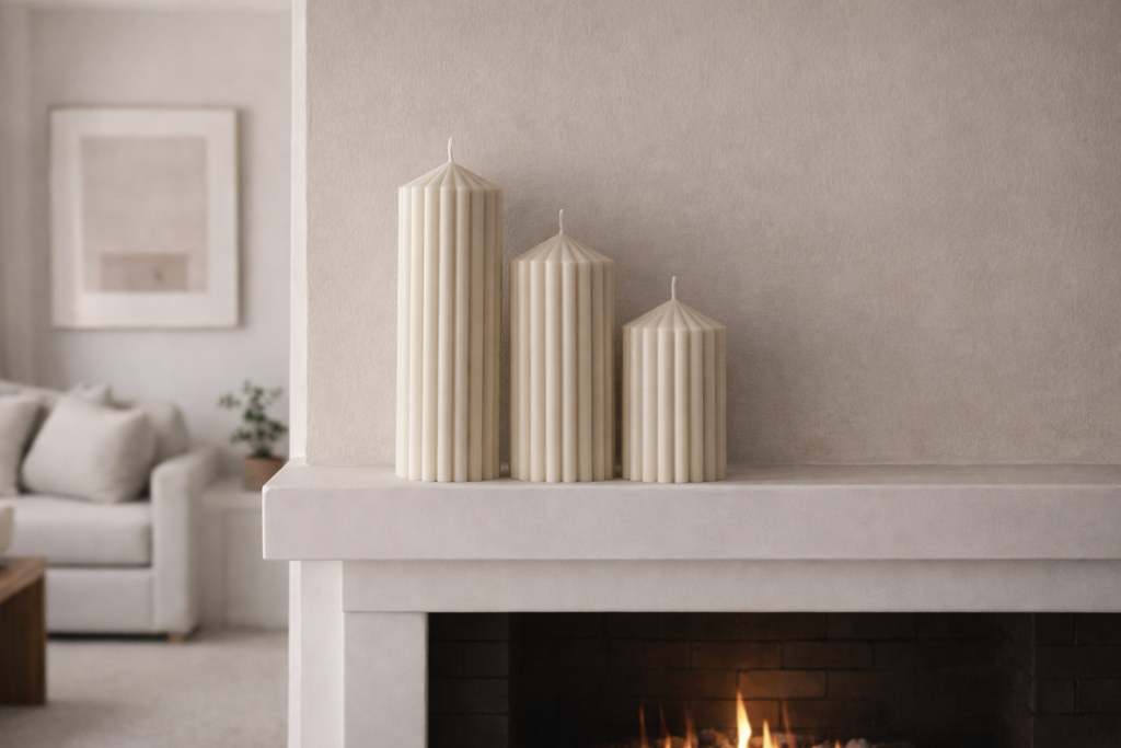 Ribbed pillar candle set styled on a modern fireplace mantel creating a clean neutral interior decor look with sculptural candle forms.
