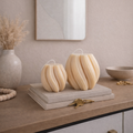 Set of swirl candles styled on console table with neutral decor accents, sculptural handmade candles for modern interiors.
