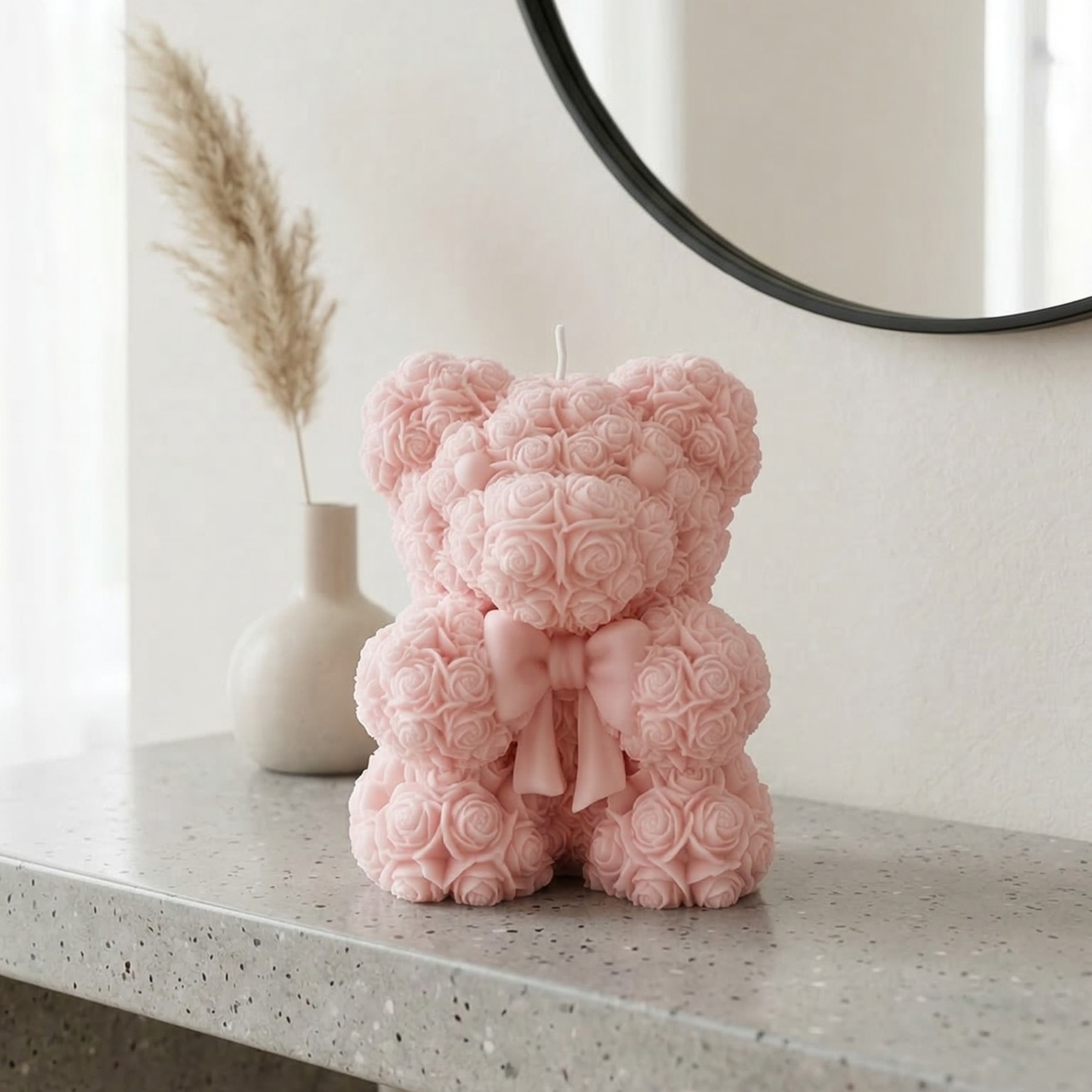 Light pink teddy bear candle with bow styled on a minimalist console table with soft decor elements
