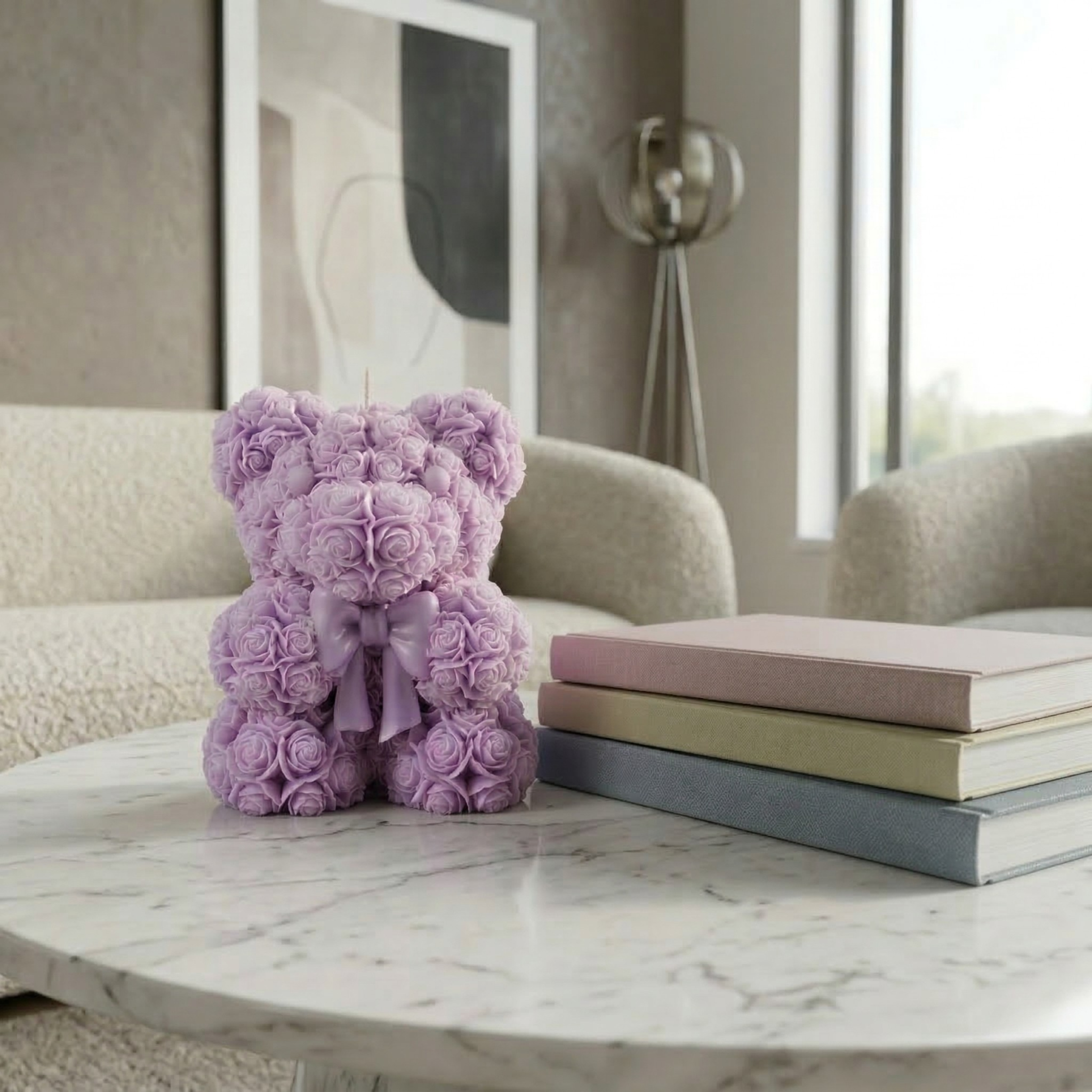 Purple teddy bear candle with bow design styled on a marble table in a soft modern home interior